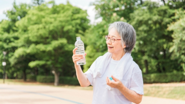 運動中に水を飲む60代女性